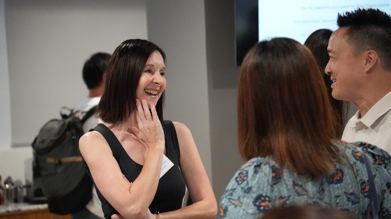 Teacher engaging with parents during the school’s information evening.