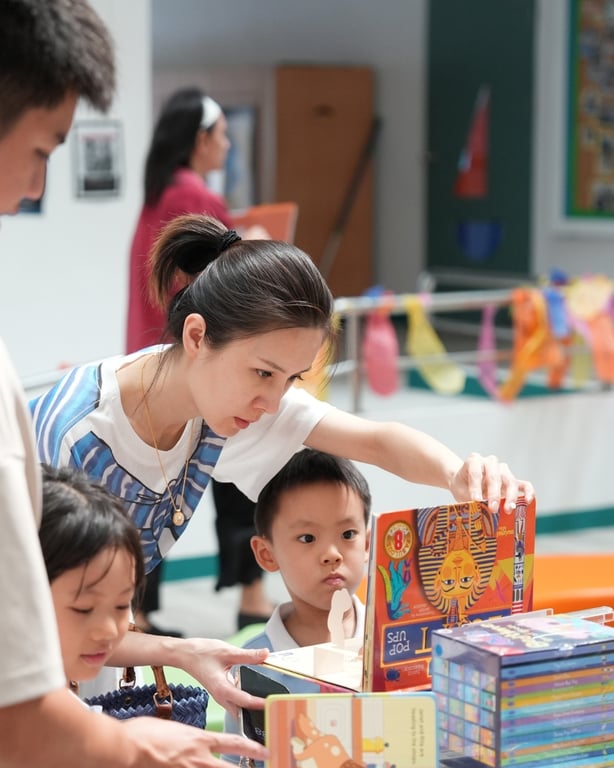 Families exploring new reads together at the KIS Book Fair.