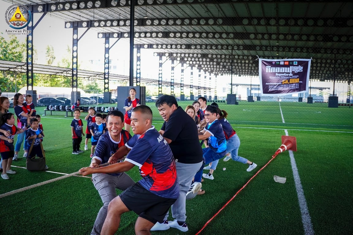 Parents and teachers competing in a tug-of-war match.