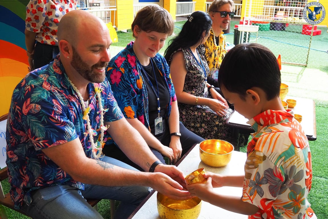 Teacher receiving water blessing from a student during Songkran.