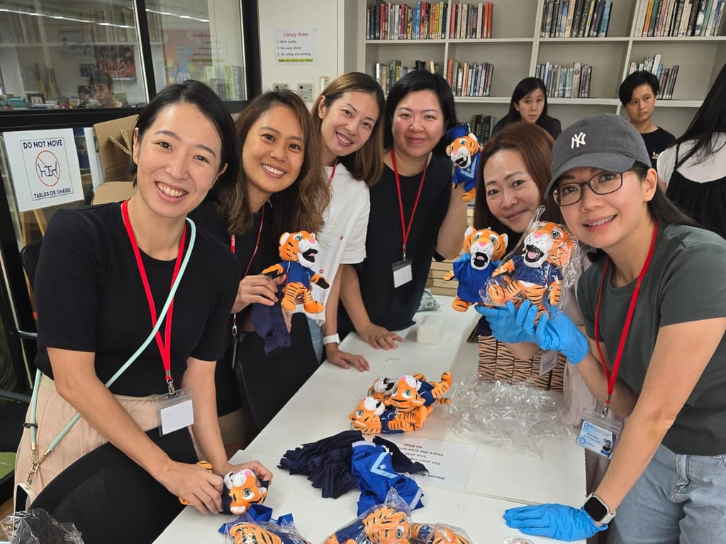 Smiling PIPTA volunteers proudly preparing graduation gifts for Reception and Year 6 students at KIS.