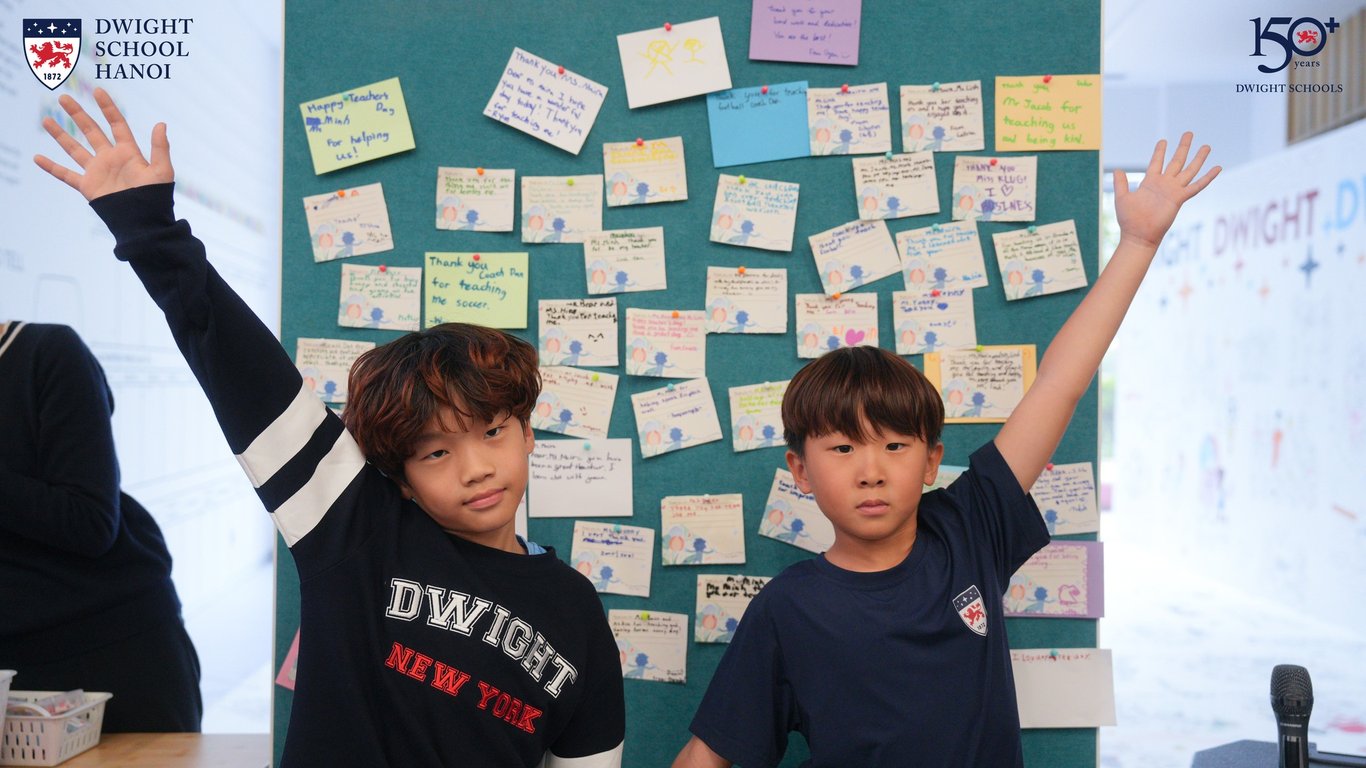 Two students posing proudly beside handwritten thank-you messages.