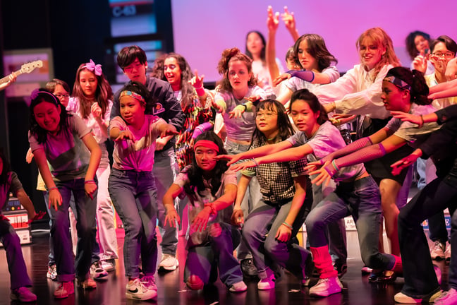Students performing in The Mixtape, an original 1980s-themed school production.