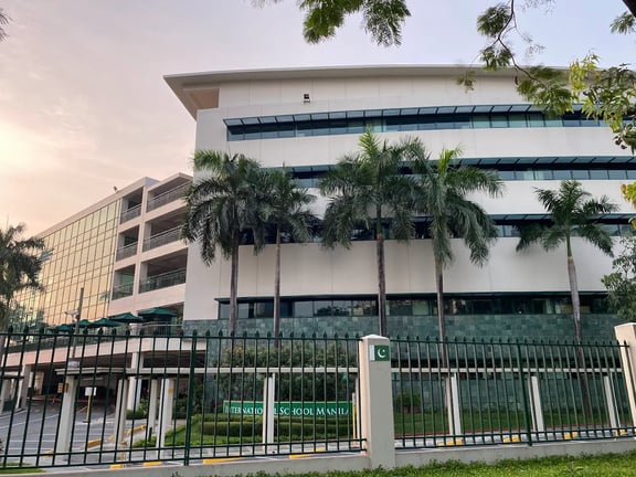 Tropical palm trees surrounding the campus building.