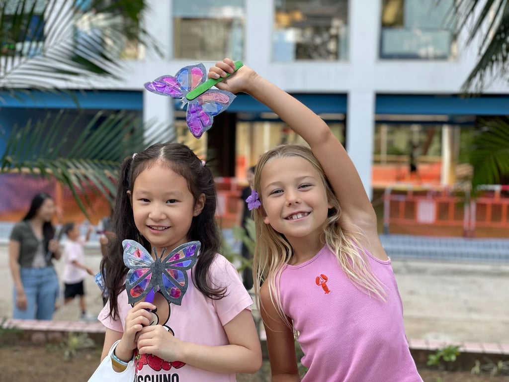 Primary students showing their colourful butterfly creations.