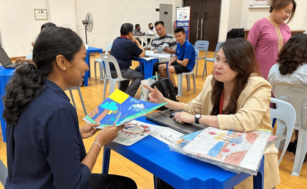 Parent and teacher reviewing student drawings during the parent-teacher conference.