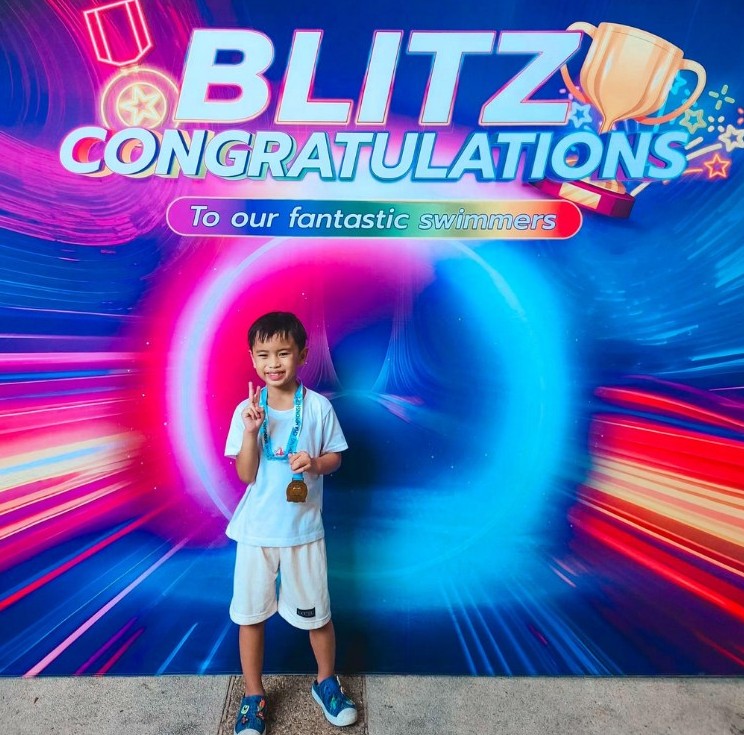 A young swimmer celebrates after a school swim meet.