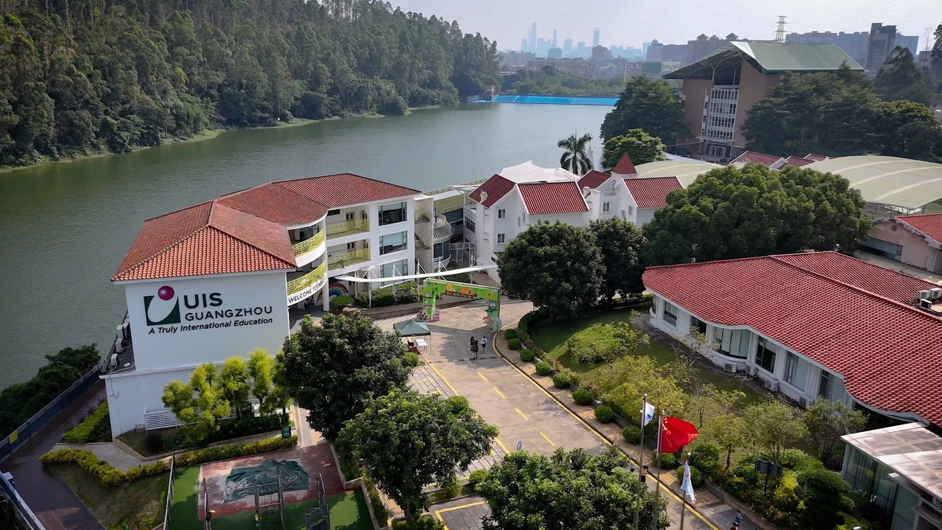 The scenic lakeside campus of Utahloy International School Guangzhou during a bright day.