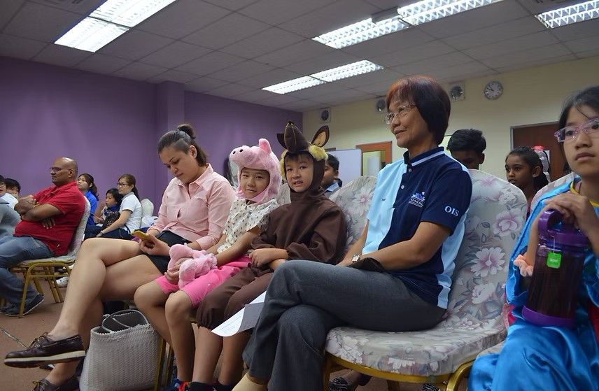 Young students dressed in animal costumes with support from parents and staff creating a warm community vibe.