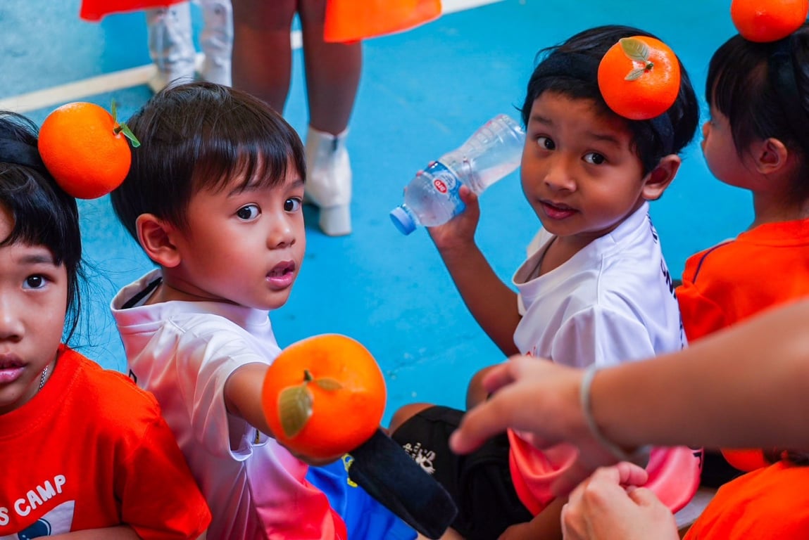Children dressed up with oranges for the friendship games.
