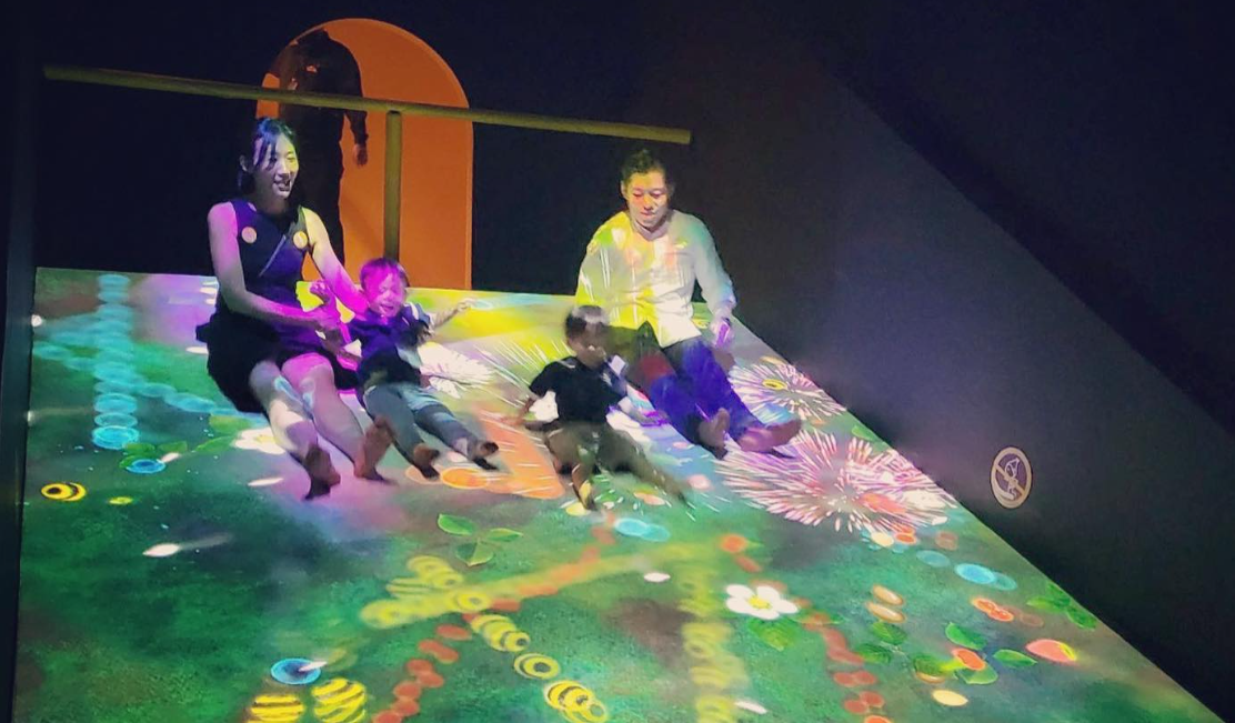 Children having experimental fun with friends, teachers, and family during a visit to the Art Science Museum.