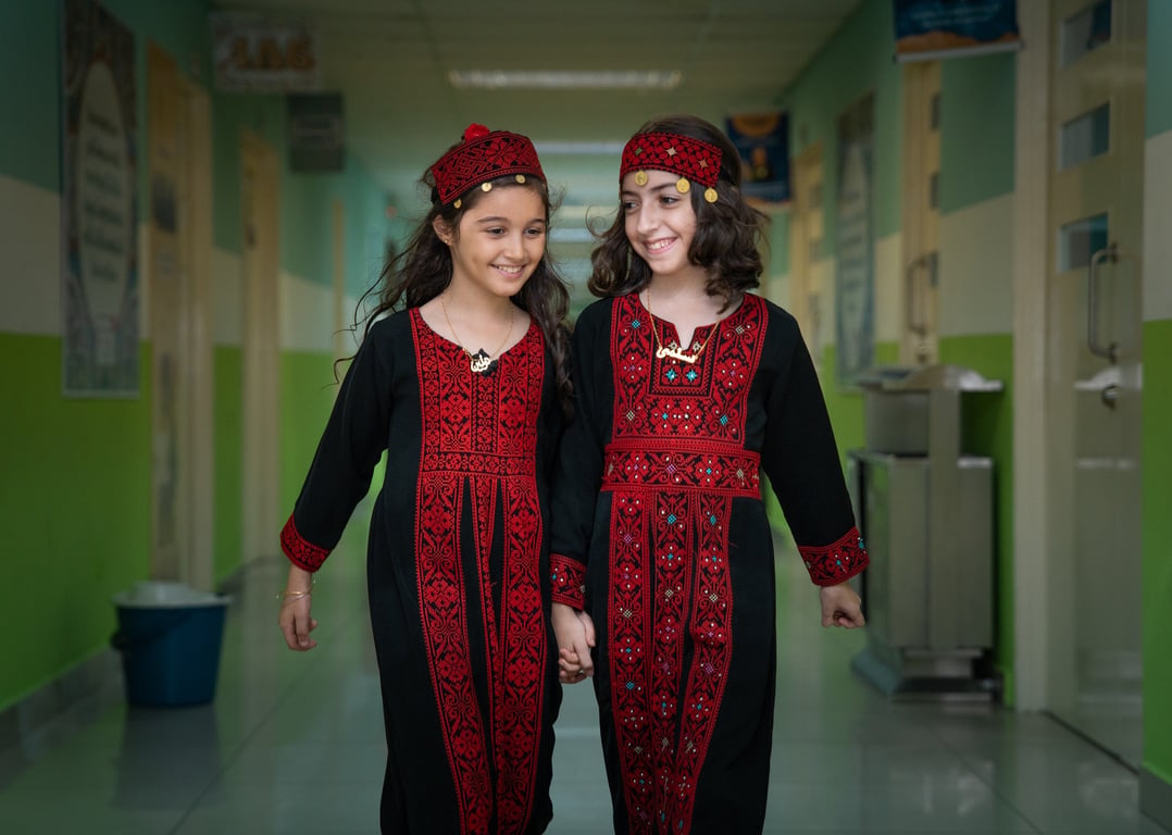 Two students dressed up in traditional arabic clothing for an event.
