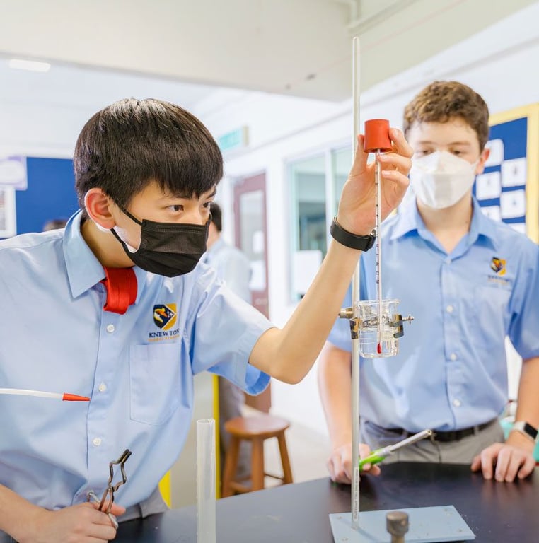 Students carefully measuring liquids during a chemistry lab.