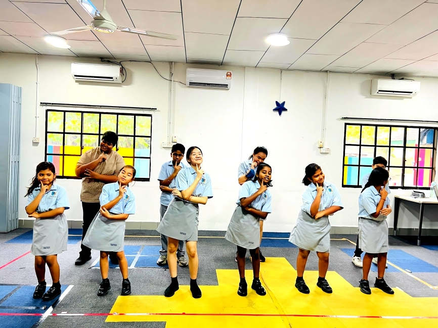 Students practicing a group dance routine in the activity hall.