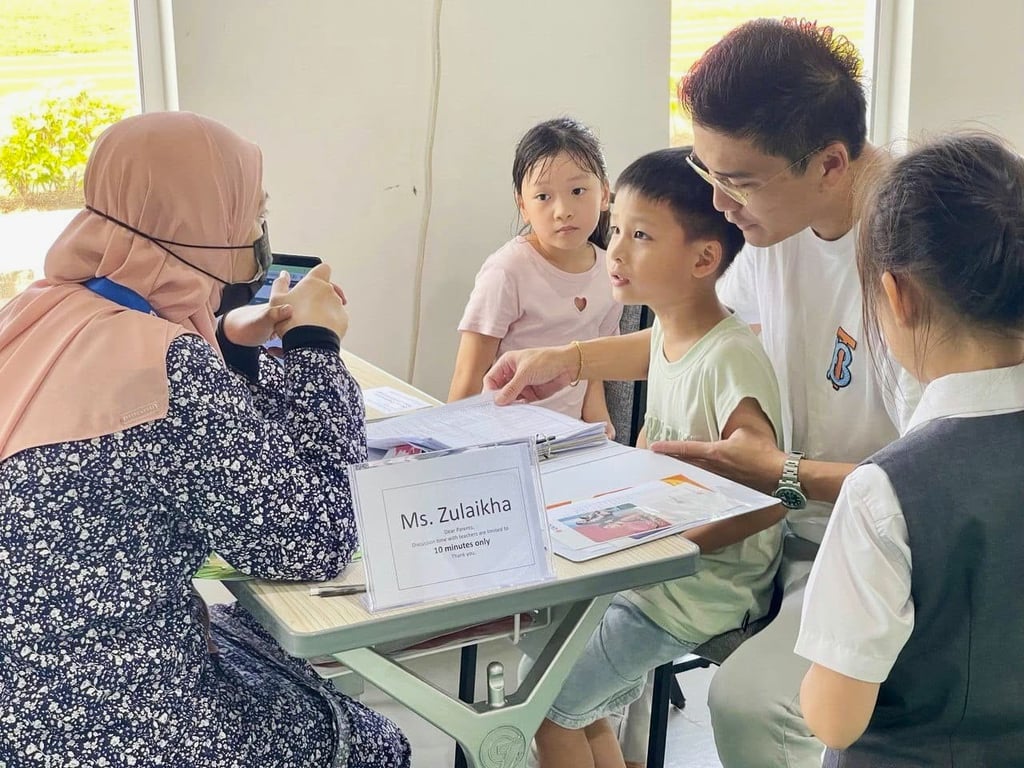 A PISM teacher engages in a progress discussion with a student and their family during a scheduled parent-teacher meeting.