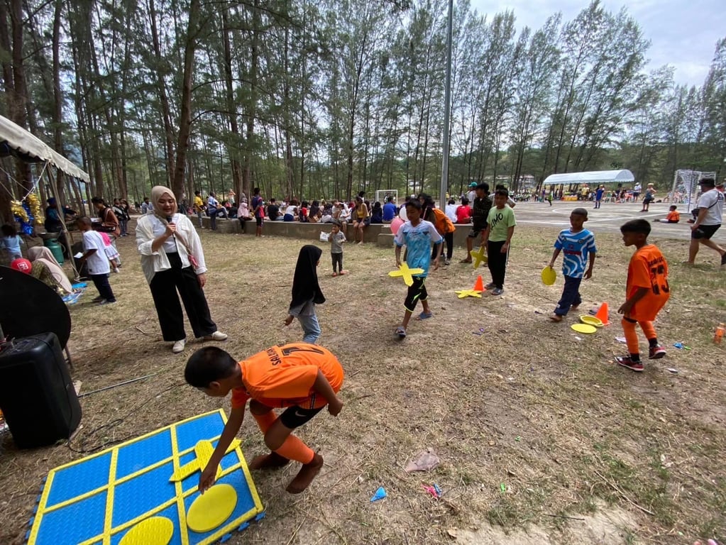 Children playing a large outdoor tic-tac-toe game during an outdoor event.