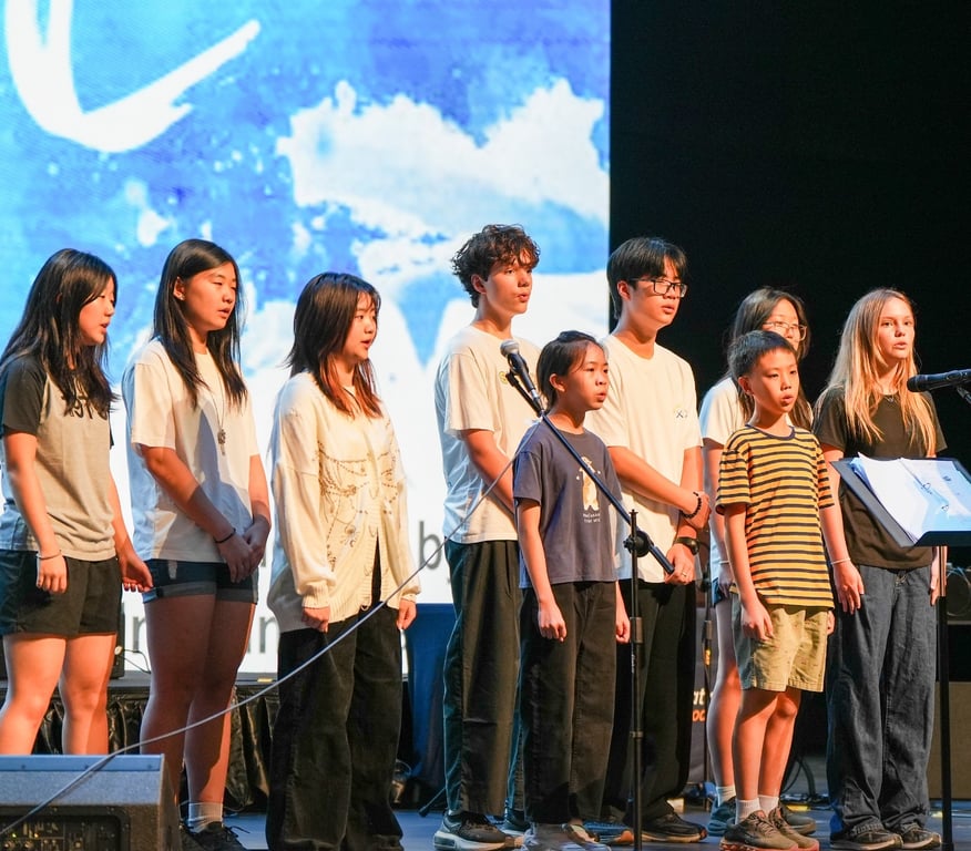 Students rehearsing together on the school theatre stage.