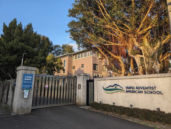 Main building and entrance gate of the Taipei Adventist American School.