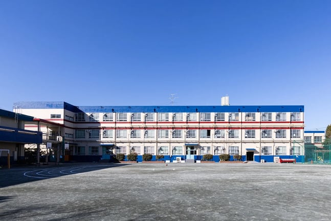 A wide view of the academic building and spacious outdoor sports field.