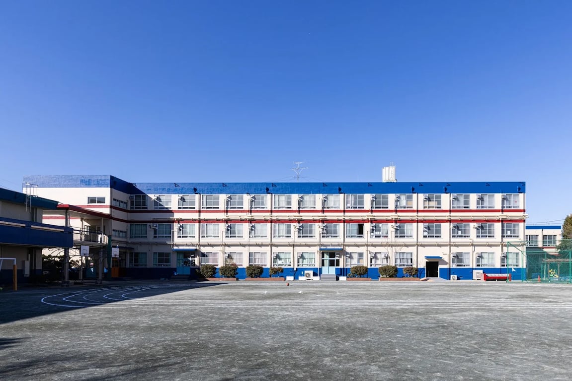 A wide view of the academic building and spacious outdoor sports field.