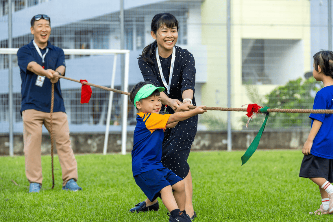 Teacher and student teaming up in a tug-of-war during Sports Day.