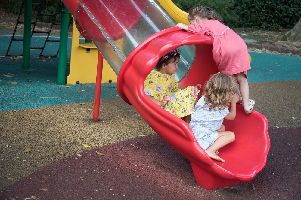 Children playing on a slide in the outdoor playground