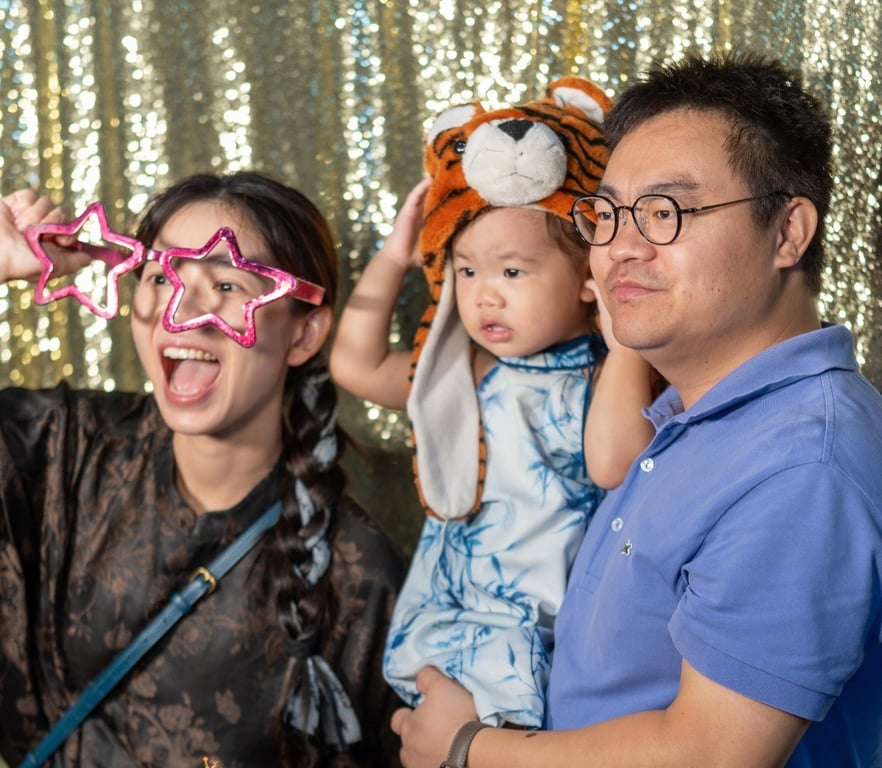 A family posing for a picture in the Open Day Carnival.
