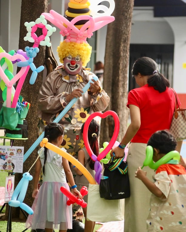 A clown delighted children and families with colorful balloon creations, filling the Open Day event with laughter, fun, and festive energy.