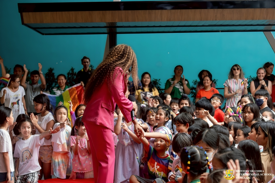 Children interact excitedly with guest during school program.