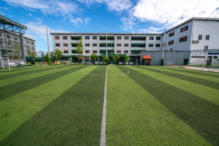 A view of the multi-story academic building and sports field.