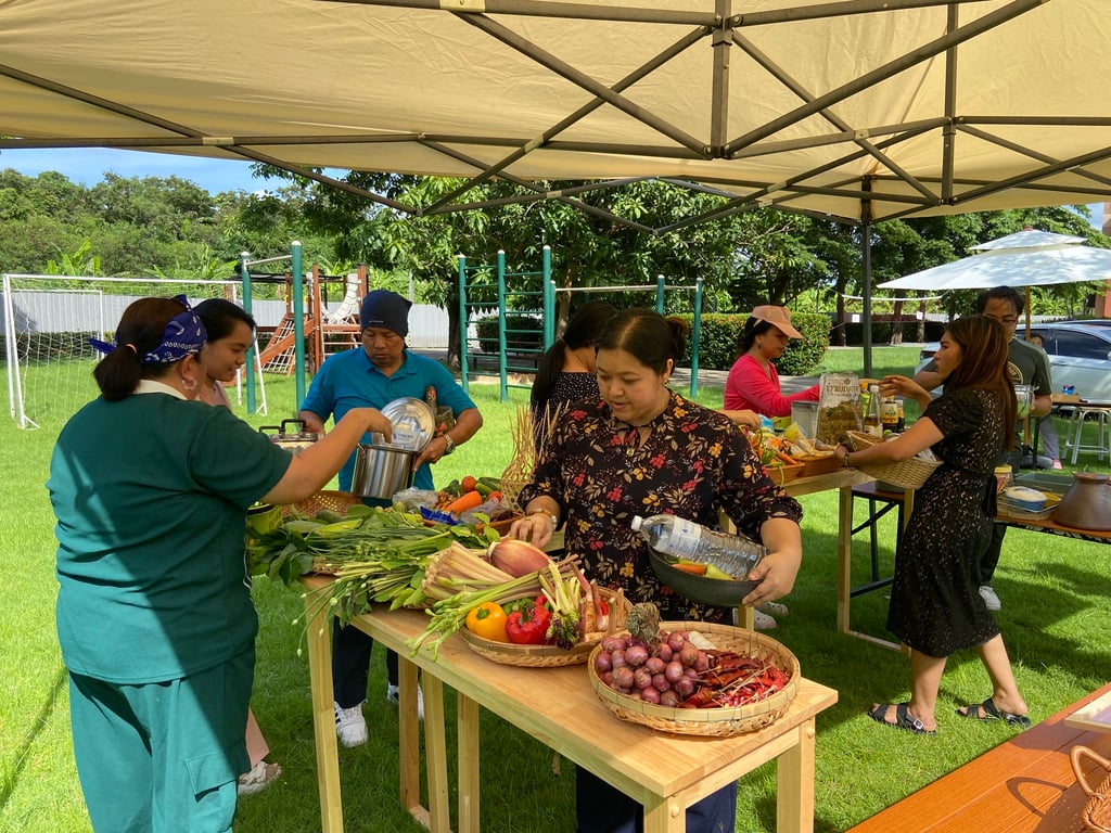 Foreign teachers learning authentic Thai cooking techniques together.