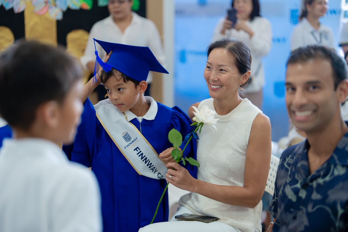 Kindergarten student celebrating graduation with family.
