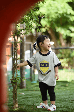 Child enjoying nature in the school’s outdoor space.