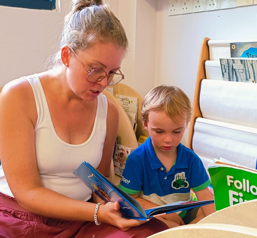 Parent and child reading together during the EYFS Stay and Play session.