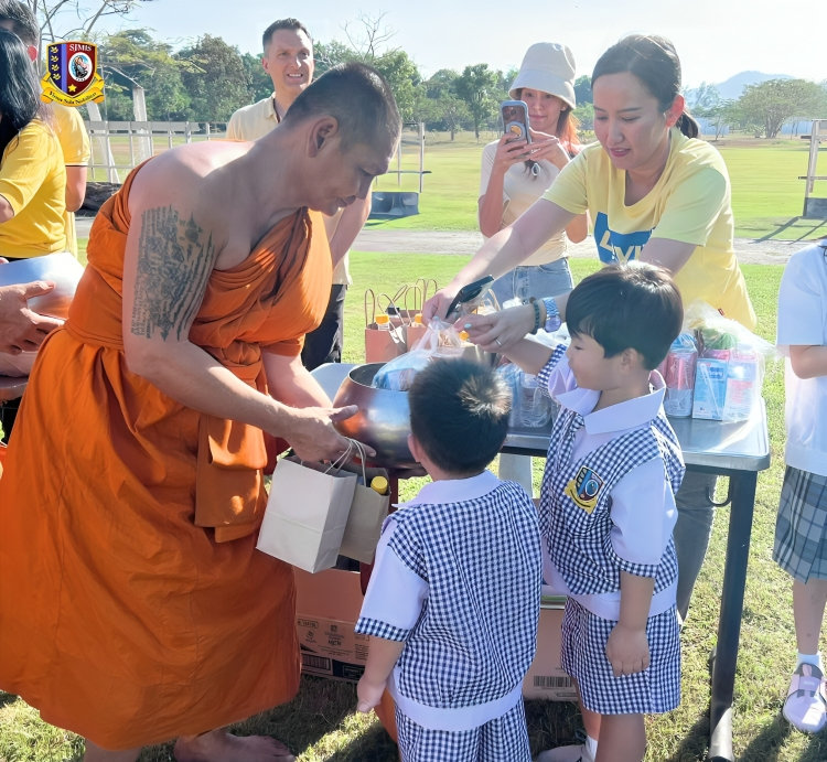 Children participating in merit-making tradition at school event.