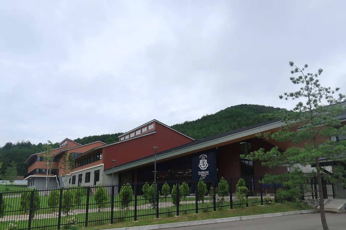 The modern brick-red academic buildings of Harrow International School Appi Japan.
