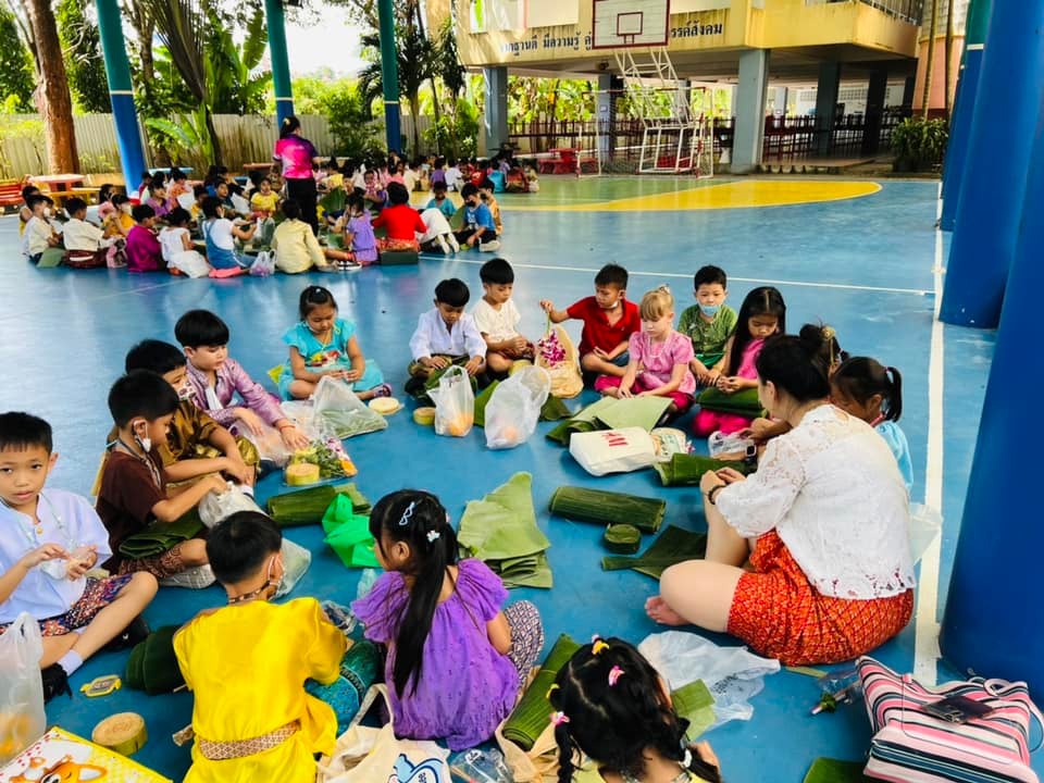 Hands-on activity wrapping krathongs during Loy Krathong celebration.