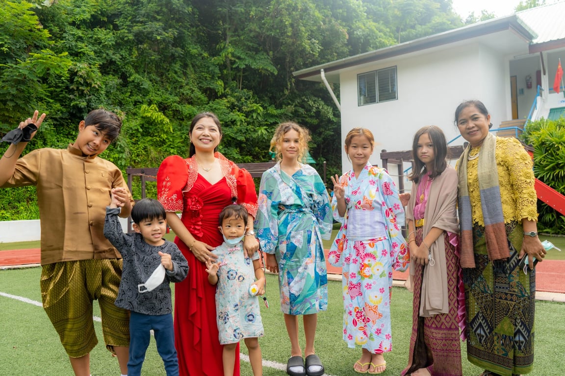 Families posing in traditional dresses at the International Day event.