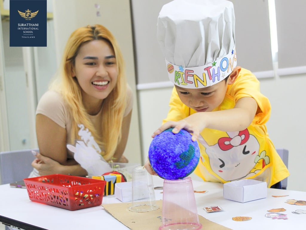 Young learner presenting a craft project during Summer Camp Showcase.