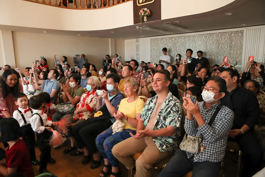 An enthusiastic audience of parents and loved ones enjoys a school performance.