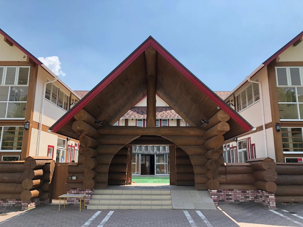 The unique log cabin style entrance welcoming students to Aichi International School.