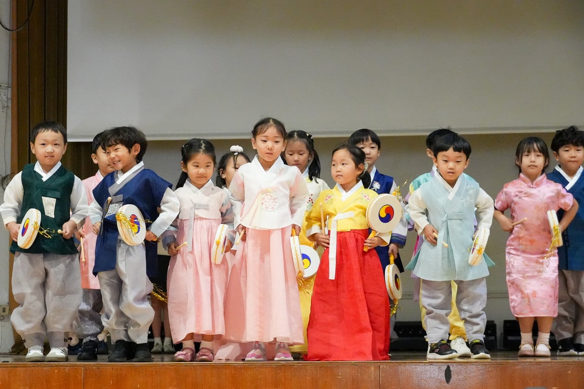 Primary students performing the vibrant Sogo Dance in traditional Korean attire during the Chuseok Assembly celebration.