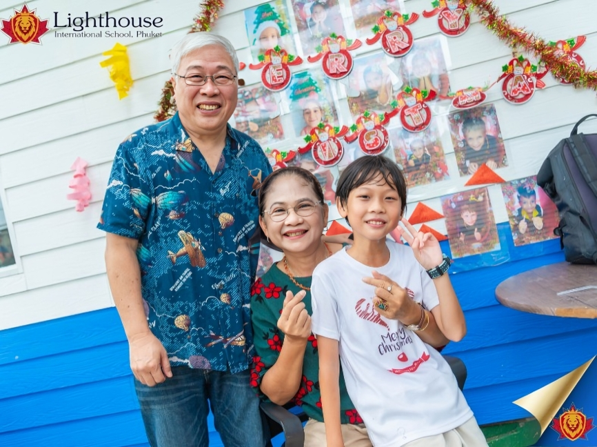 Family photo in front of a festive classroom display.