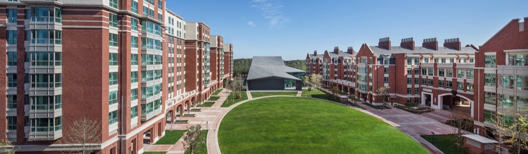 Traditional red brick architecture surrounding the expansive central campus green.