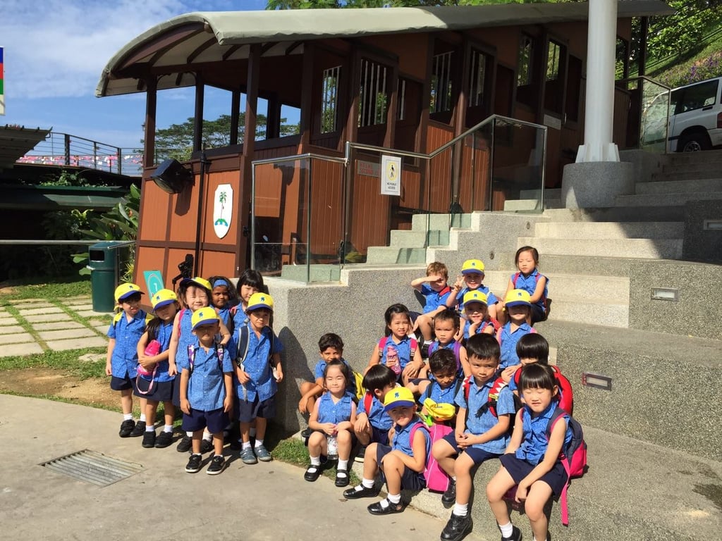 Primary students gather for a group photo during a sunny school outing.