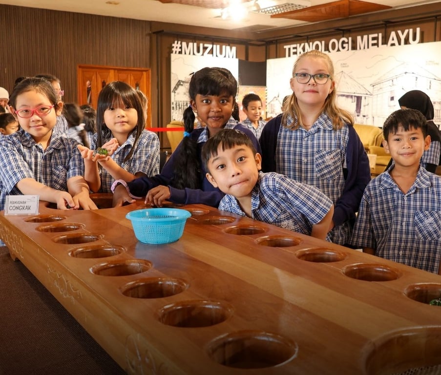 Primary students play congkak, a traditional Southeast Asian game, during a cultural field trip.