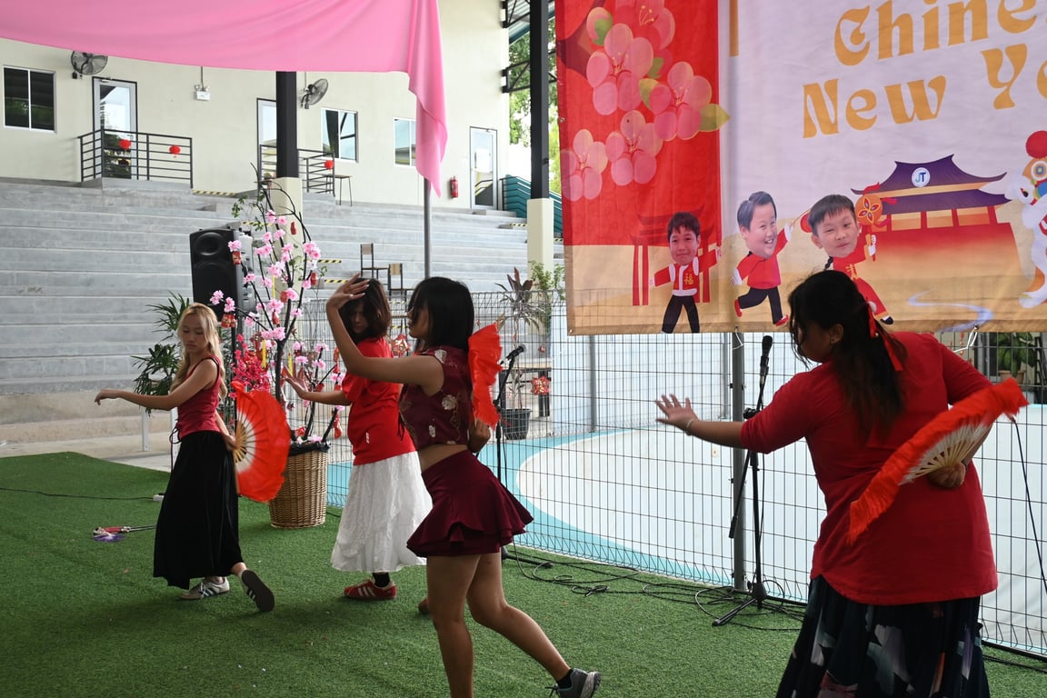 Students perform a traditional fan dance during the school’s Chinese New Year celebrations.