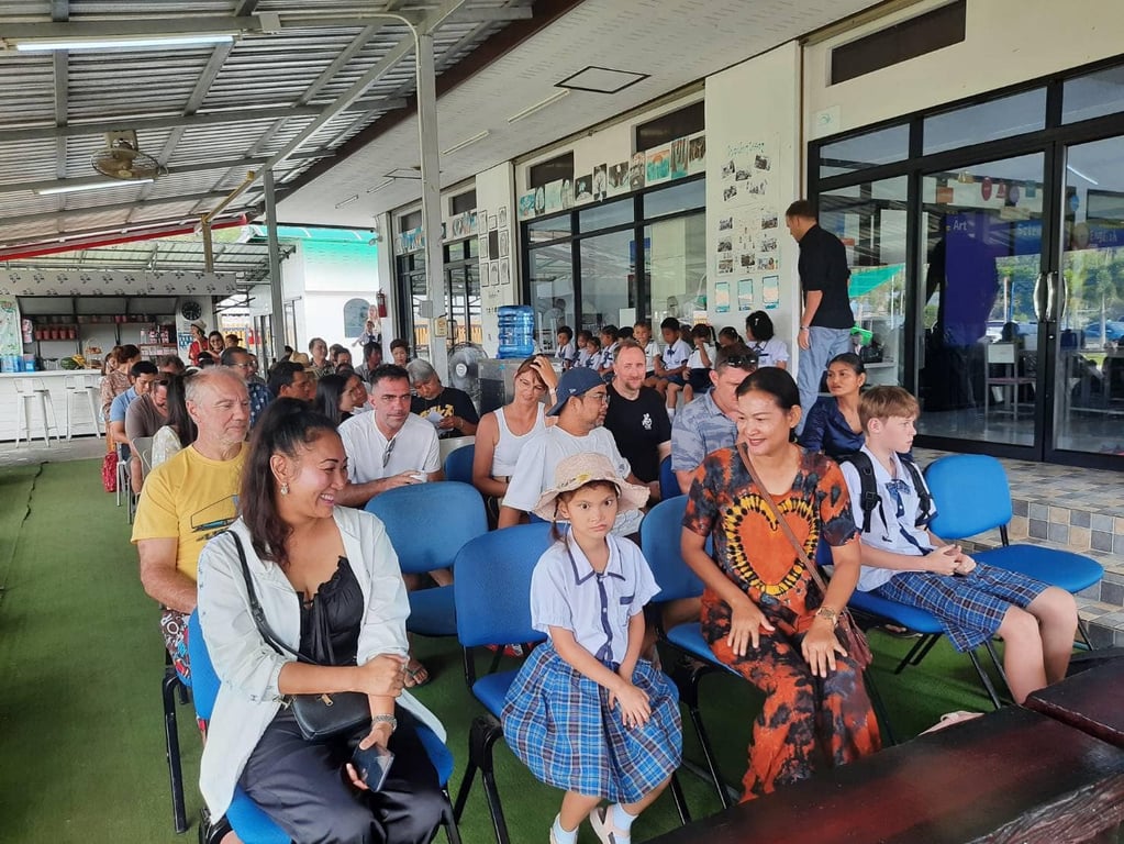 Parents and students seated for a parent meeting at school assembly.