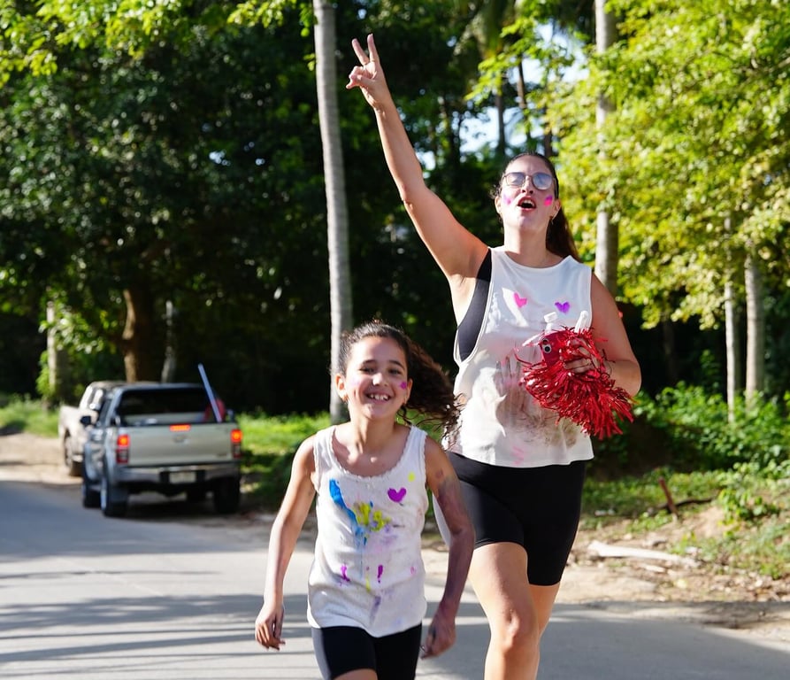 Parent and student running together during the school’s color fun run.