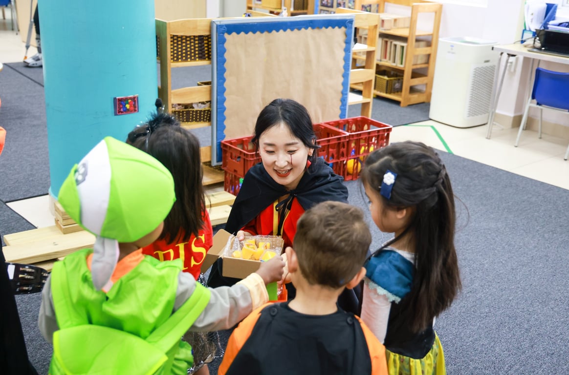 Parent volunteers handing out treats during the Halloween celebration.